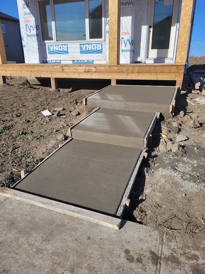 Fresh concrete steps and landing poured at the entry of a new-build home