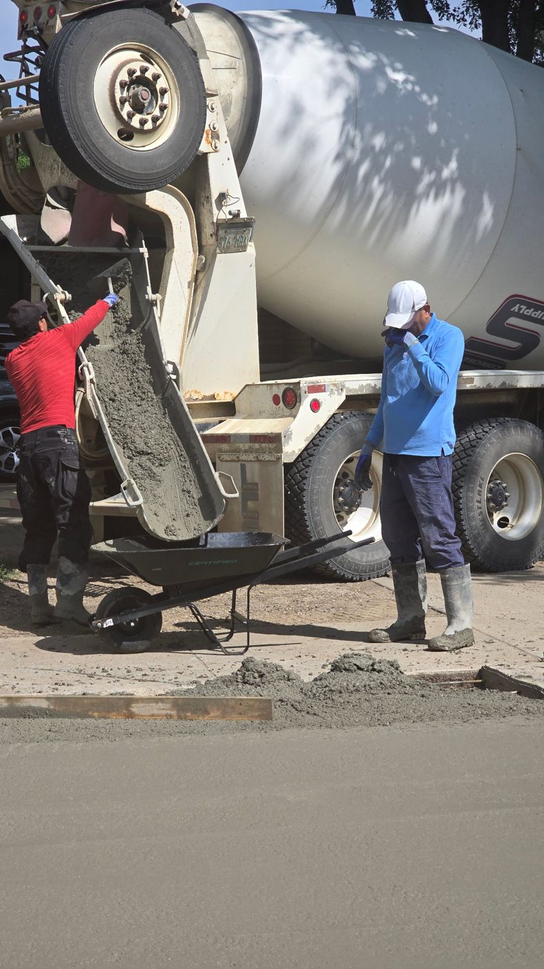 Concrete being placed from the mixer chute into a wheelbarrow on a Saskatoon driveway pour