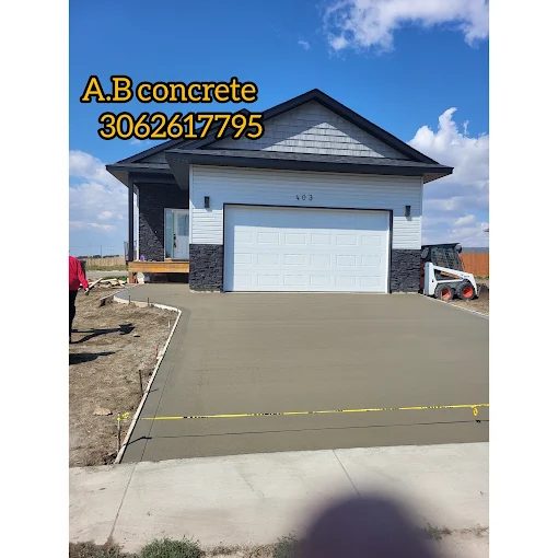 Wide broom-finish concrete driveway leading to a double garage